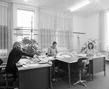 882591 Afbeelding van drie medewerkers op de afdeling administratie in het kantoorgebouw van de R.E.M.U. (Nicolaas ...
